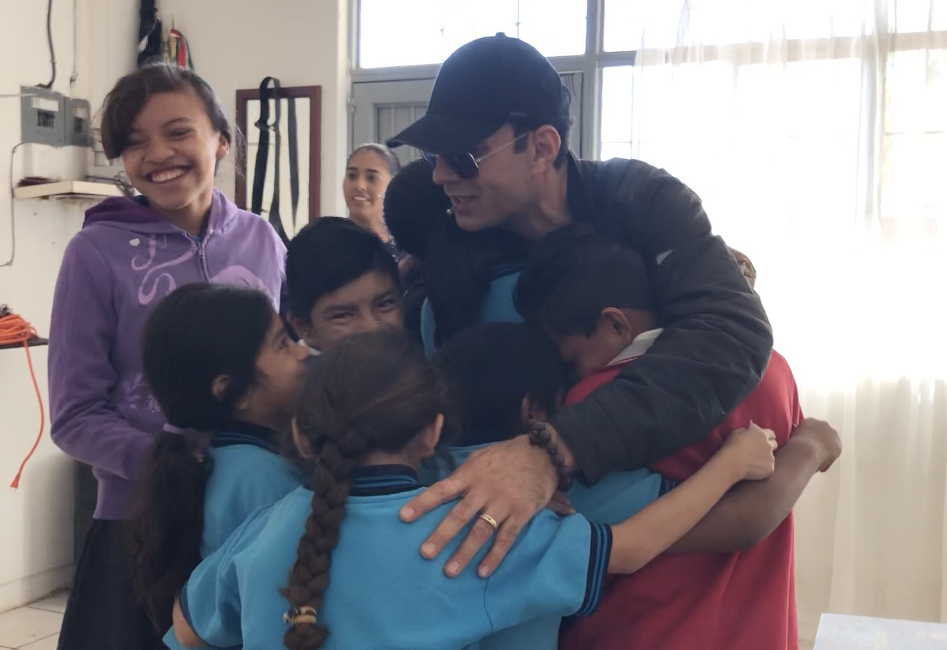 Richard Zaher hugging with kids from a Mexican school