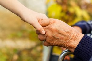 an elderly hand is holding the hand of a young person